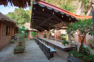eine Terrasse mit Tisch und Bänken und Bäumen in der Unterkunft Cat Ba Mountain View Homestay in Cát Bà