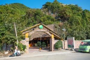 a building with an archway in front of a mountain at Cat Ba Mountain View Homestay in Cat Ba