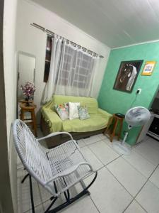 a living room with a couch and a chair at Flat imobiliado feitosa in Maceió