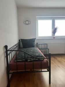a bed sitting in a room with two windows at AK Ferien-Monteurwohnung in Olpe