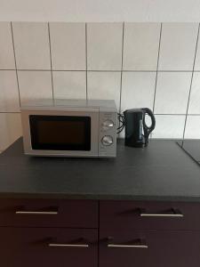 eine Mikrowelle auf einer Theke mit Kaffeetasse in der Unterkunft AK Ferien-Monteurwohnung in Olpe