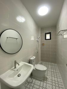 a bathroom with a sink and a toilet and a mirror at โฮมสเตย์ สุขสำราญ รีสอร์ท 