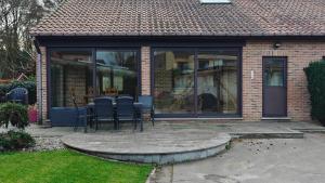 a patio with chairs and a table in a house at Brelaarheide in Aan de Wolfsberg