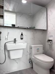 a white bathroom with a toilet and a sink at Eunhasu D&M Residence Cheongcho 4 in Daejeon