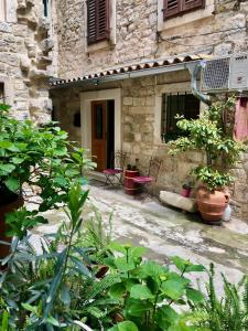 a stone house with chairs and plants in front of it at Apartment Venus of the Palace - NEW RENOVATED in Split