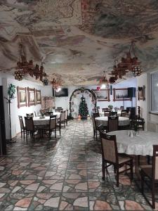 una sala da pranzo con tavoli, sedie e un albero di Natale di Parusa Maklaia a Baturyn