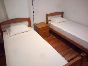 a room with two beds and a night stand with two beds at Airport 5 minutes by car - 24h check in in Santa Cruz