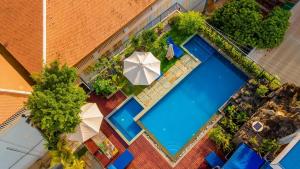 an overhead view of a swimming pool with an umbrella at SIEM REAP RIVER VIEW Residence in Siem Reap