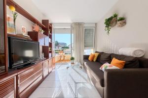sala de estar con sofá y TV de pantalla plana en Piso de dos habitaciones en playa de Ris- Noja, en Noja