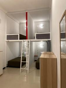 a small room with a bunk bed and a room with a desk at ReVive by Snooze in Banyuwangi