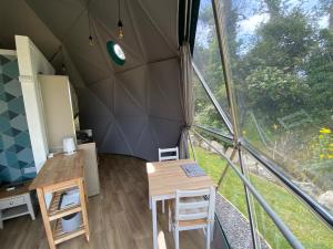 a room with a table and chairs in a tent at Benllech Glamping in Benllech