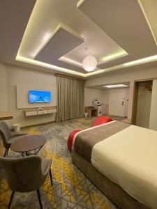 a hotel room with a bed and a flat screen tv at فندق جولدن توليب أبها - GOLDEN TULIP ABHA HOTEl in Abha