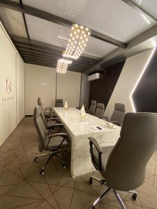 una sala de conferencias con una mesa larga y sillas en فندق جولدن توليب أبها - GOLDEN TULIP ABHA HOTEl en Abha
