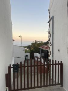 einen Zaun vor einem weißen Gebäude mit dem Ozean im Hintergrund in der Unterkunft El Isleño in Valverde