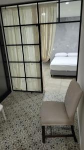 ein Schlafzimmer mit einem Bett und einem Stuhl in einem Zimmer in der Unterkunft Casa de Verano in Mina Clavero