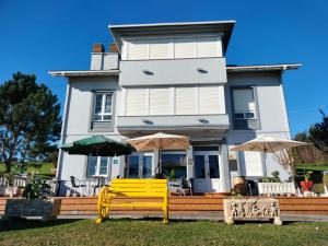a house with a yellow bench in front of it at Hotel Capellan in Navia