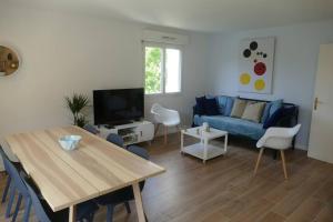 a living room with a blue couch and a table at Disneyland Paris, appartement 70m², parking privé in Serris