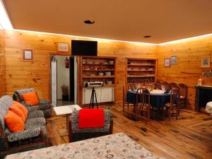 una sala de estar con mesa, sillas y paredes de madera. en Hotel Capellan, en Navia