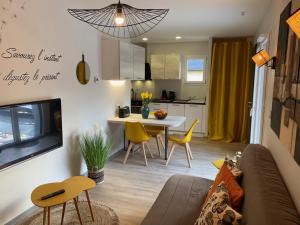 a living room and kitchen with a couch and a table at Latitude Savoie in Drumettaz-Clarafond