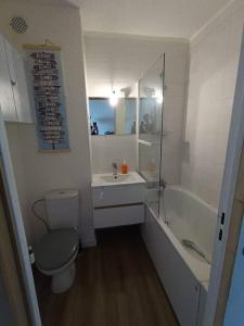 a bathroom with a toilet and a sink and a tub at Appartement T2, proche de la mer in Seignosse