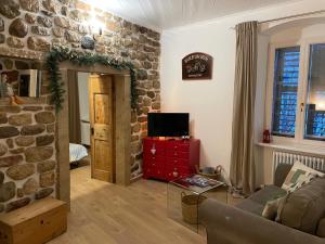 un soggiorno con un divano e un muro di pietra di Casetta alla fontana a Villa Lagarina