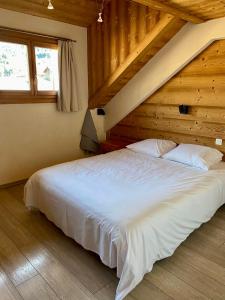1 dormitorio con 1 cama blanca grande en una habitación en Les Azalées 6 en Les Gets