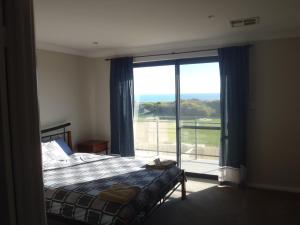1 dormitorio con cama y ventana grande en Port Denison Beach Resort, en Port Denison