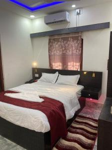 ein Schlafzimmer mit einem großen Bett mit einer roten Decke in der Unterkunft Royalwood City Inn in Birātnagar