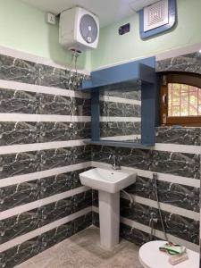 a bathroom with a sink and a tv on the wall at Royalwood City Inn in Birātnagar