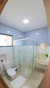 a bathroom with a shower and a toilet and a sink at Blue House Vale do Capão in Palmeiras