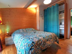 a bedroom with a bed and a wooden wall at La Mélisse 