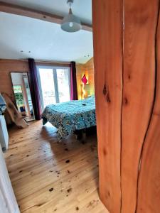 a bedroom with a bed and a wooden floor at La Mélisse 
