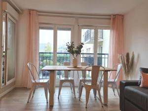 a table and chairs in a living room with a window at Appartement 3 chambres, 9P, Hyper centre Disney in Chessy