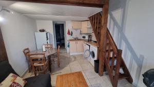 uma cozinha e sala de jantar com uma mesa e uma escada em Maison climatisée dans résidence avec piscine em Saint-Cyprien