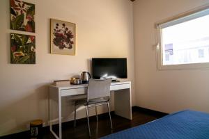 a bedroom with a desk with a computer and a chair at Villa Marlene B&B in Albenga