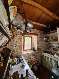 a small kitchen with a stove and a window at Cottage Casa Vinela in Buje