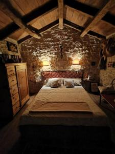 a bedroom with a large bed in a stone wall at Cottage Casa Vinela in Buje