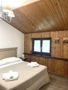 2 łóżka w sypialni z drewnianymi ścianami i oknem w obiekcie HOTEL CAMPO STELLA w mieście Leonessa +22 zdjęcia