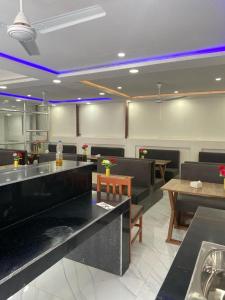 ein Restaurant mit Tischen und Stühlen und eine Bar in der Unterkunft Royalwood City Inn in Birātnagar