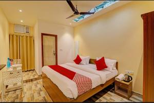 een slaapkamer met een groot bed met rode kussens bij RR PALACE in Gorakhpur