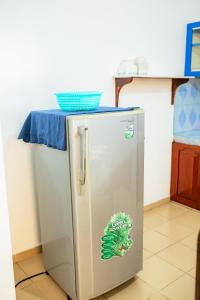 a stainless steel refrigerator with a blue table on top at Summer Lanka Surf House in Hikkaduwa