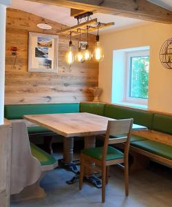 a dining room with a wooden table and green seats at Appartement Berndlhof Mitterberg - Gröbming - Schladming in Gersdorf
