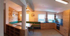 a kitchen with a wooden table and green chairs at Appartement Berndlhof Mitterberg - Gröbming - Schladming in Gersdorf