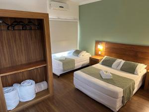 um quarto de hotel com duas camas e um espelho em La Torre Jaguarão em Jaguarão