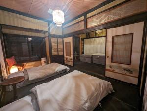 a bedroom with two beds and a chandelier at 源泉かけ流し温泉＆プライベートサウナ付き一棟貸しVilla SOUQ Echigo-yuzawa Hanare in Yuzawa