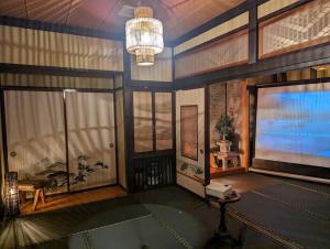 um quarto grande com uma tela de projeção e uma mesa em 源泉かけ流し温泉＆プライベートサウナ付き一棟貸しVilla SOUQ Echigo-yuzawa Hanare em Yuzawa