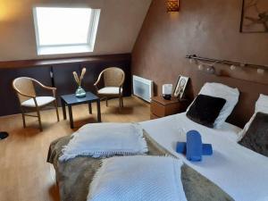 een slaapkamer met een groot bed met stoelen en een raam bij Maison proche Disneyland Paris in Ozoir-la-Ferrière