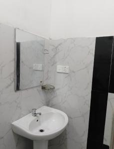 a white bathroom with a sink and a mirror at Villa kandupamula in Mirissa