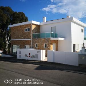un edificio con una valla blanca delante de él en Residencial Monte Gordo Golf Rei Algarve, en Monte Gordo