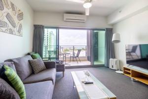 - un salon avec un canapé et une télévision dans l'établissement Habour & City View Apartment on 11th Floor - King Bed, à Darwin